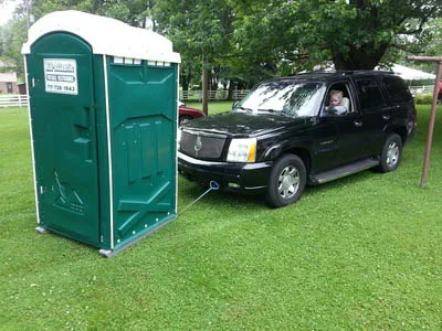 car moving a portable restroom that will make the special event a success